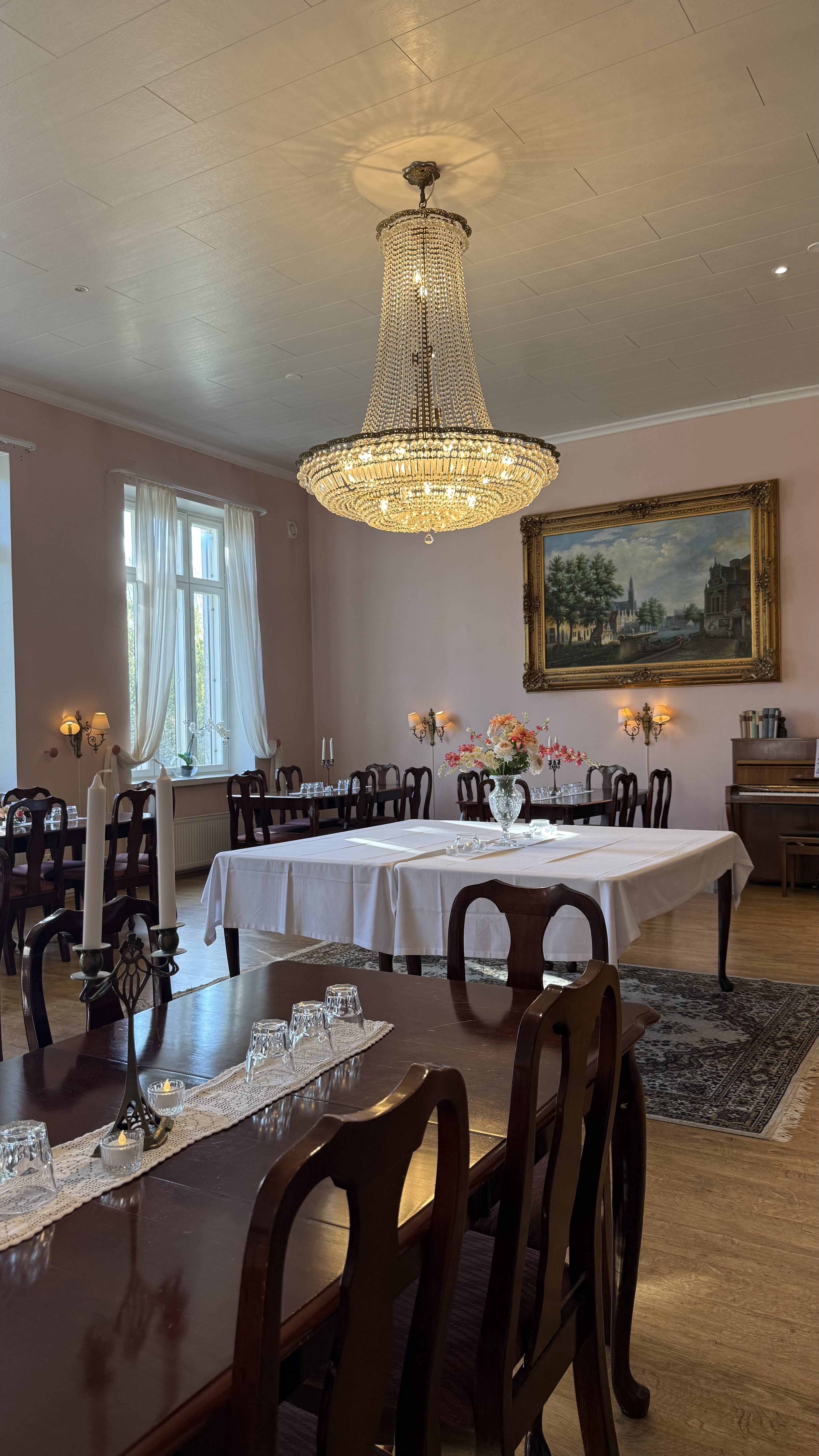 Satulinnan salonki kristallikruunuineen ja katettuine pöytineen